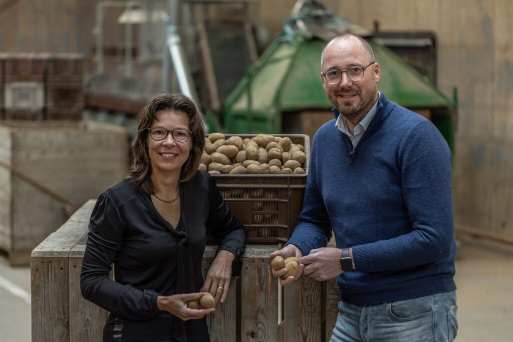 Gea Bakker (Rabobank) en Cor van Veldhuijsen (Agrofoodcluster) voor een krat met aardappelen